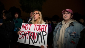 Protesters hold up signs and yell during a protest in Boston