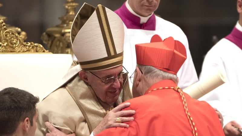 Pope Francis places the red three-cornered biretta hat on the head of new Irish cardinal Kevin Joseph Farrell
