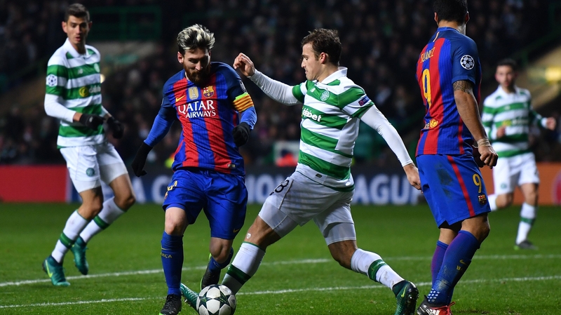 Lionel Messi of Barcelona (L) is tackled by Tomas Rogic of Celtic (C)