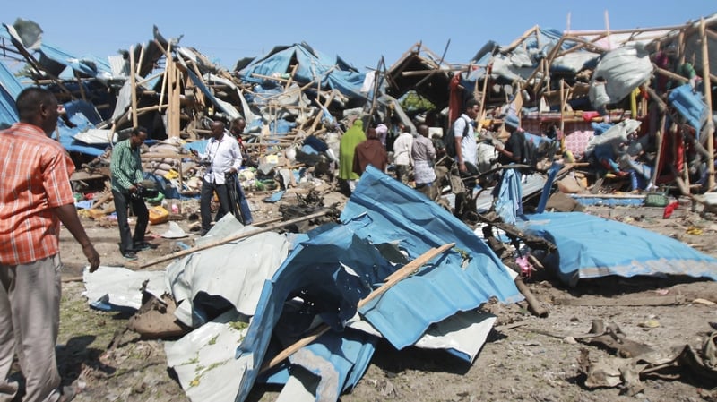 People gather at car bomb attack scene in a busy market in Mogadishu