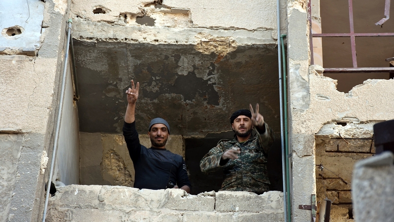 Syrian soldiers make a V for victory sign in Aleppo's eastern Masaken Hanano area