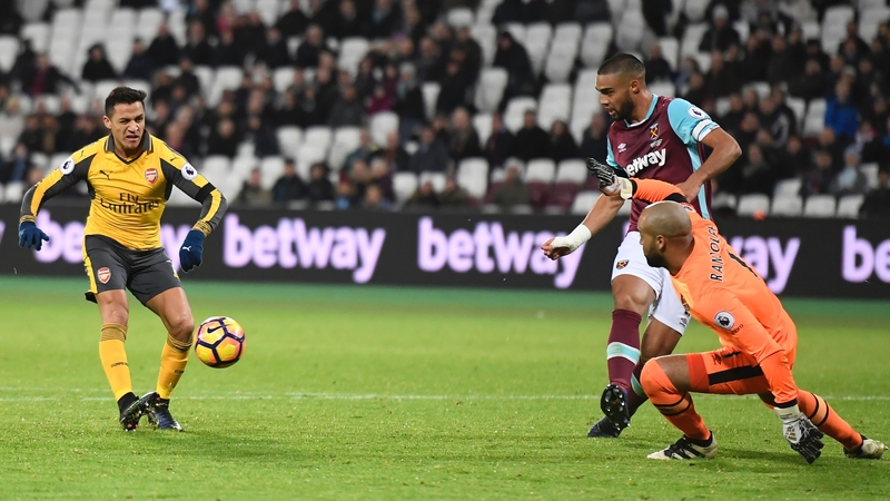 Alexis Sanchez of Arsenal gives West Ham's Irish goalkeeper Darren Randolph the eyes before dinking the ball into the net