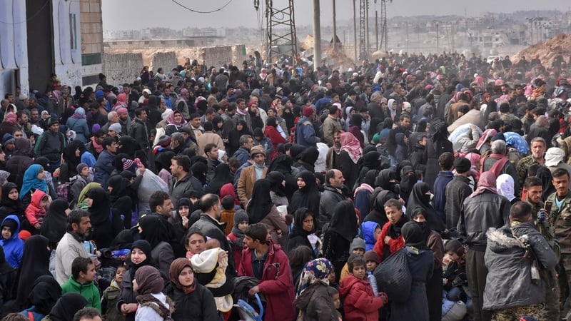 Syrian families, fleeing from various eastern districts of Aleppo, queue to get onto governmental buses