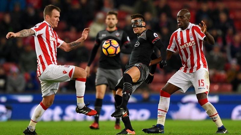 Dusan Tadic (C) of Southampton controls the ball under pressure of Glenn Whelan (L) and Bruno Martins Indi