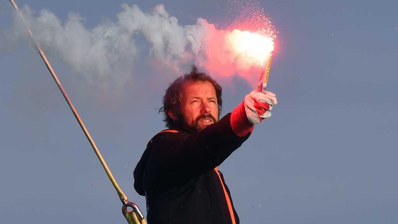 French skipper Thomas Coville holds a burning flare onboard his 'Sodebo Ultim' multihull as he arrives in the port of Brest