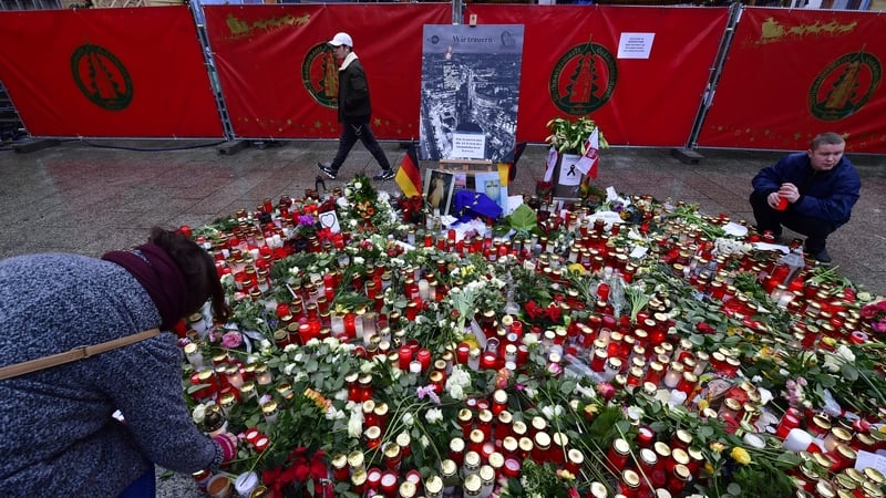 Candles are left at a tribute in the market in Berlin