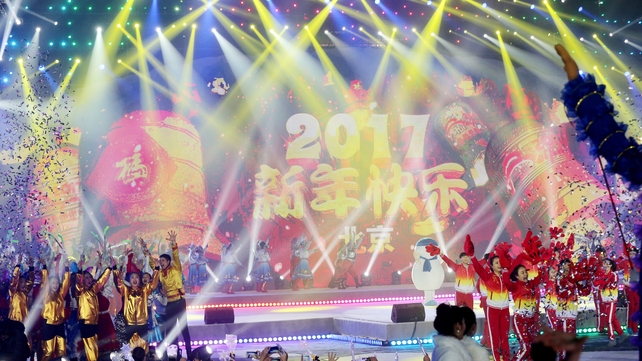 Performers celebrate during the count down event to celebrate the arrival of the 2017 at Beijing Olympic Park