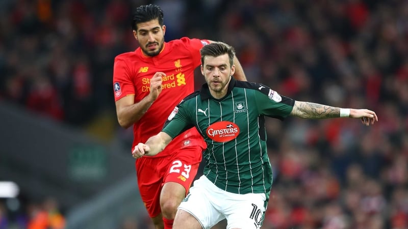 Graham Carey holds off Emre Can at Anfield
