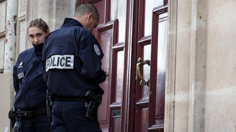 Police stand guard outside the entrance of a building in which Kim Kardashian was reportedly held up at gunpoint