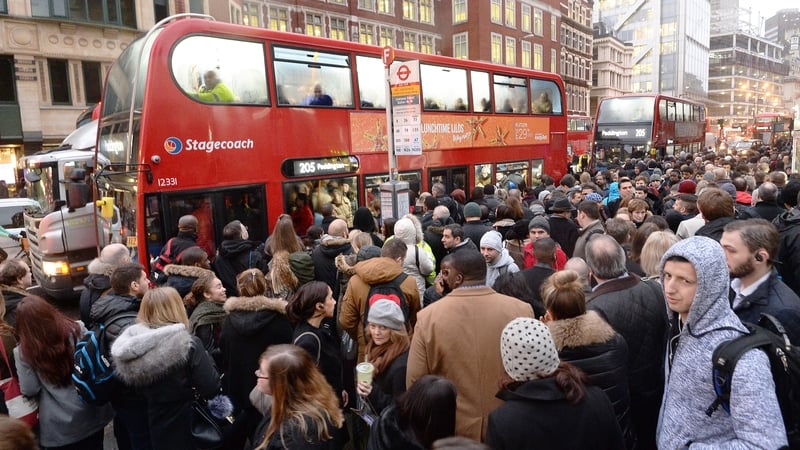 People queue for buses at Bishopsgate in the City of London