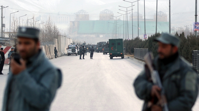 Afghan security officials block a road to parliament in Kabul after blasts
