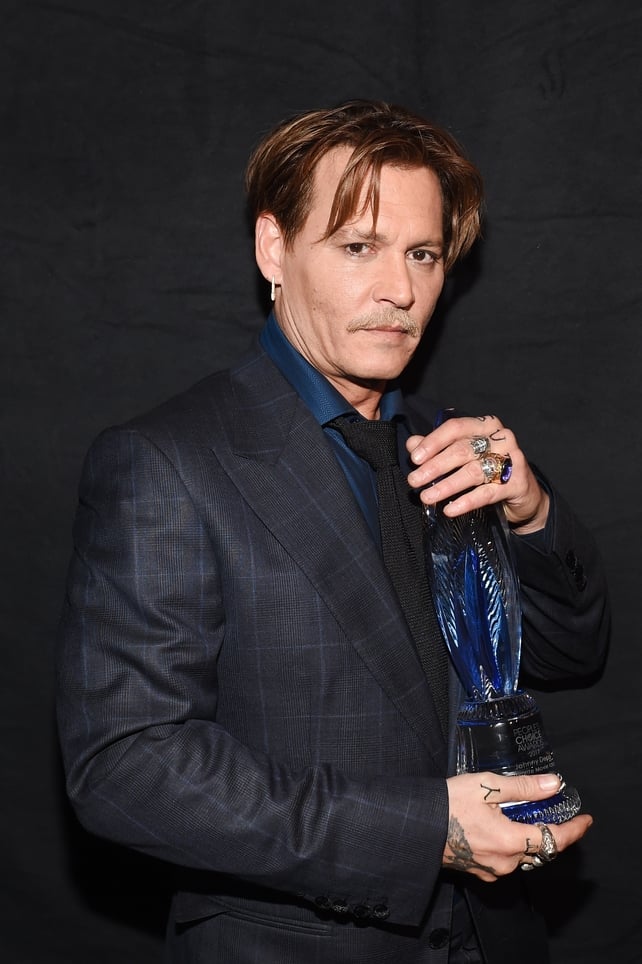 Johnny Depp also looks a little stunned pictured with his award for Favourite Movie Icon
