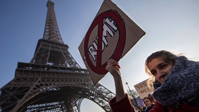 Protesters carry anti-Trump signs during the Women's March near the Eiffel Tower in Paris, France