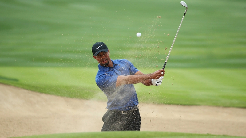 Tiger Woods plays from a bunker on the sixth hole