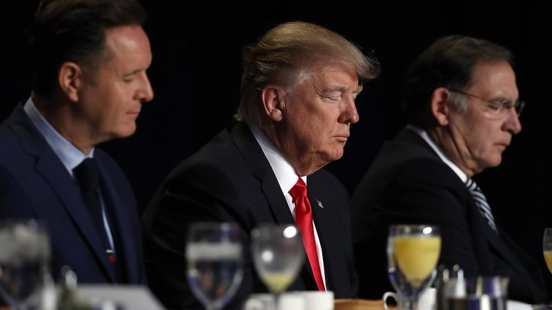 Donald Trump bows his head in prayer alongside television producer Mark Burnett (L) and Sen John Boozman