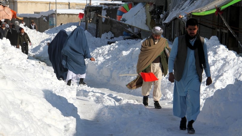 People make their way through a snowy road in Ghazni, Afghanistan today