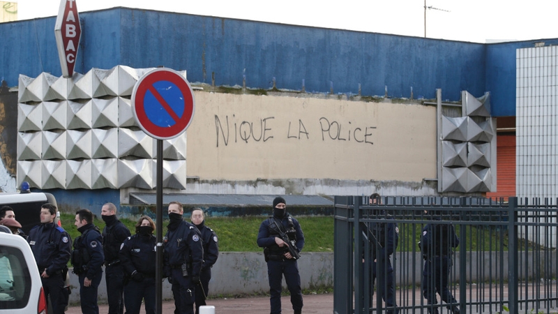 French policemen stand guard by a vandalised wall at the Rose des Vents in Aulnay-sous-Bois