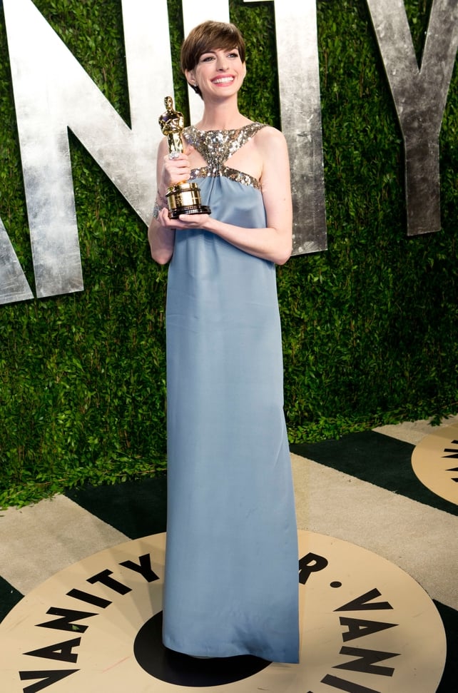 All smiles while carrying her Oscar in 2013 at the Vanity Fair Oscar Party. This blue and gold Saint Laurent gown even match the statue!
