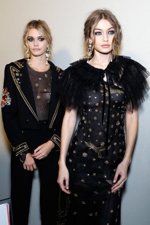 Model Gigi Hadid, and fellow model, backstage at Alberta Ferretti backstage in a magnificent embroidered dress. We love this Sicilian-inspired hairstyle.