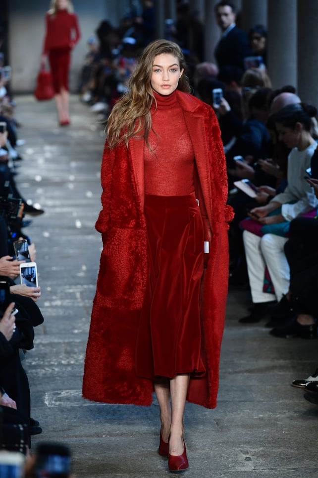 Lady in red. Gigi Hadid in a long coat and velvet skirt at the Max Mara fashion show.