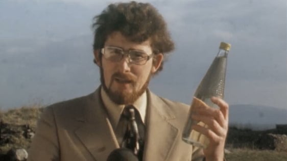 RTÉ reporter Jim Fahy holding bottle of poteen (1977)