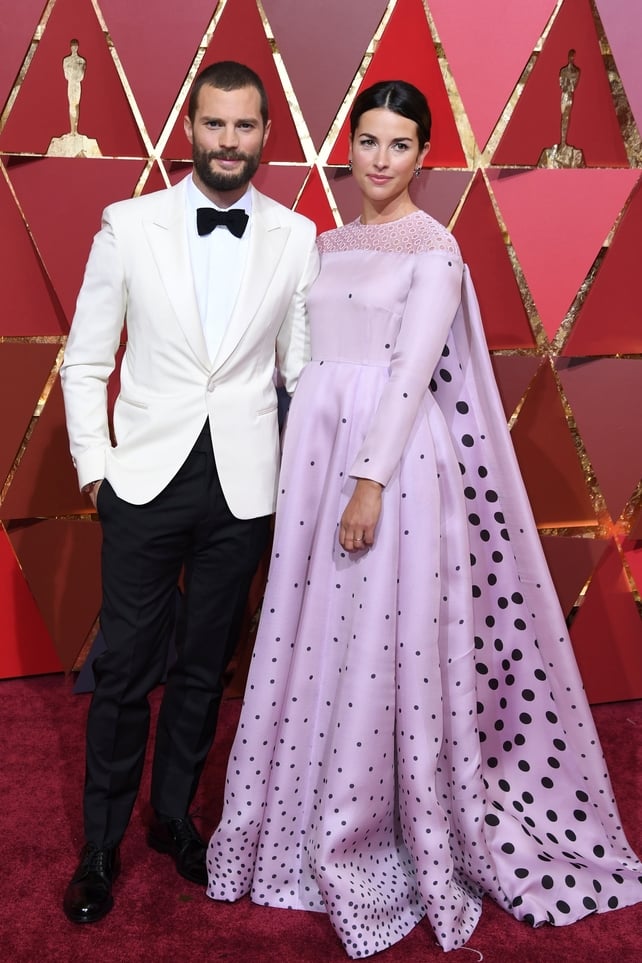 Jamie Dornan and his wife British actress Amelia Warner wore a baby pink, floor-skimming gown