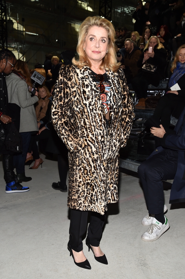 French icon Catherine Deneuve rocking a leopard print coat at the Saint Laurent Fashion Show.