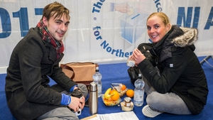 Journalism students Conor Neeson and Katie Boyd take a break while election count staff count ballot papers at the main Belfast count centre