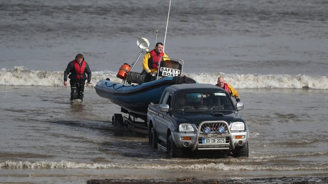 Local fishermen and members of the local community return from the search
