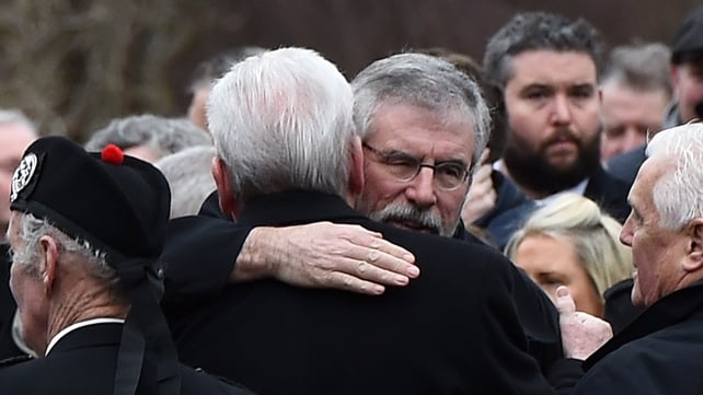Gerry Adams greets a fellow-mourner outside Martin McGuinness's home in Derry