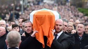 Martin McGuinness's coffin is carried as the funeral cortege passes through the streets of Derry