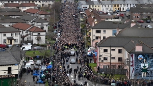 Crowds accompany the hearse carrying Martin McGuinness's coffin as it makes its way to the church