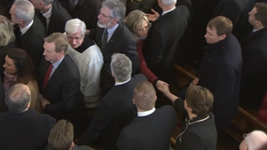 Michelle O'Neill and Arlene Foster shake hands as the funeral mass comes to an end