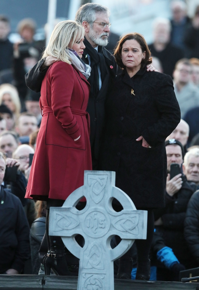 Michelle O'Neill, Gerry Adams and Mary Lou McDonald huddle together at the burial of Martin McGuinness