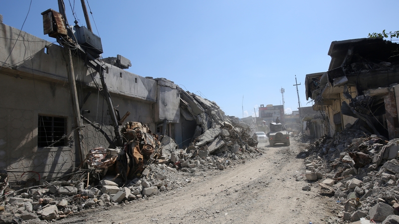 An Iraqi forces' vehicle drives past destroyed buildings in Mosul's al-Jadida area today