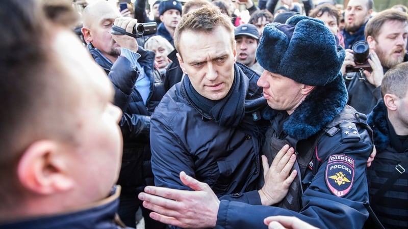 Russian opposition leader Alexei Navalny (C) was detained by Russian police officers during the opposition rally in central Moscow
