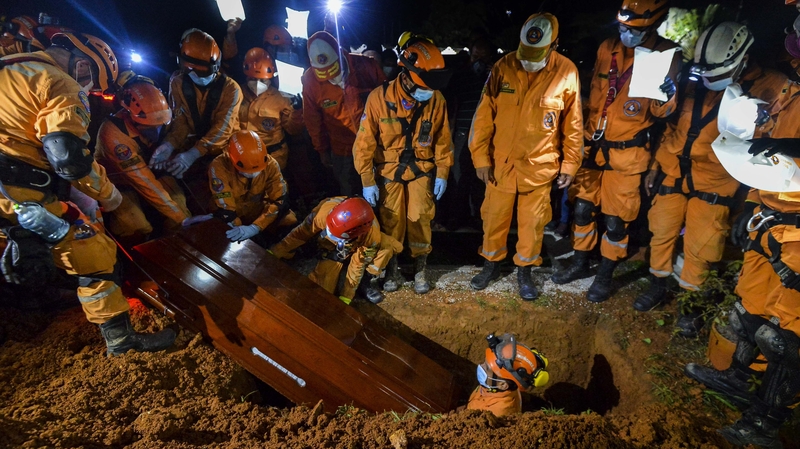 Colombian civil defence workers bury a coworker who died during the rescue effort