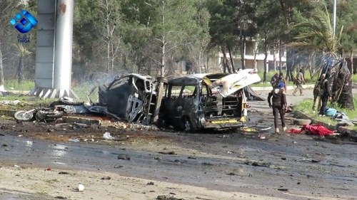 Rescue and media personnel at the scene of the car bomb attack in Rashidin, west of Aleppo