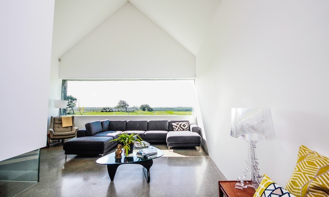 The living area is home to high ceilings and a suspended fireplace.