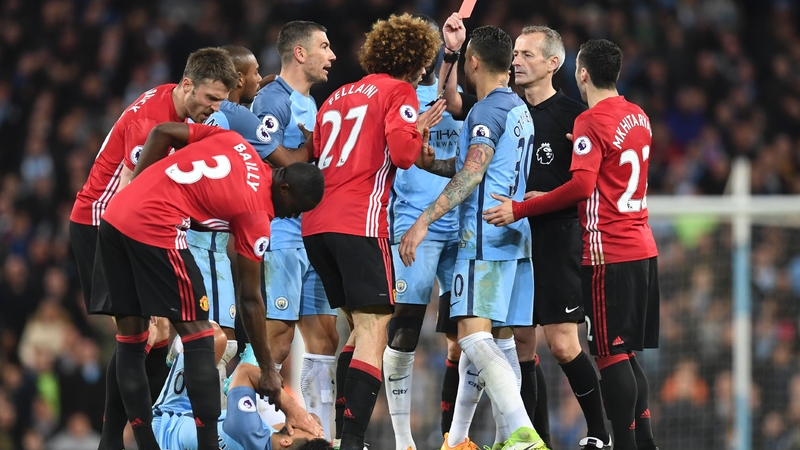 Marouane Fellaini is dismissed by referee Martin Atkinson