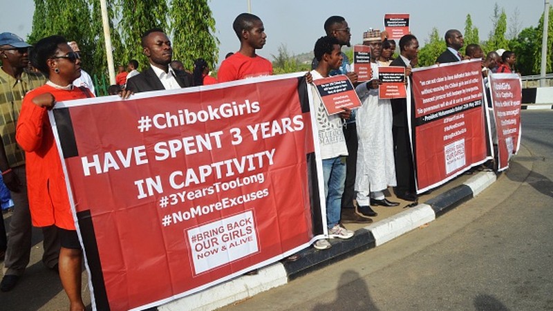 Protesters holding placards during a demonstration marking the third anniversary of the abduction of the Chibok girls in Abuja on 14 April