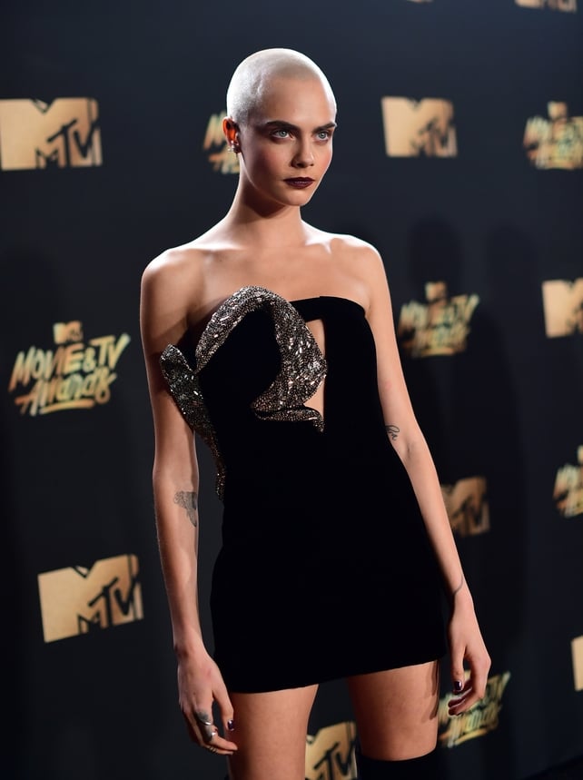 Cara Delevingne is currently rocking an extreme buzz cut for her role in 'Life in a Year', where she plays a woman with terminal cancer. She wore a strapless Saint Laurent dress and thigh high boots.