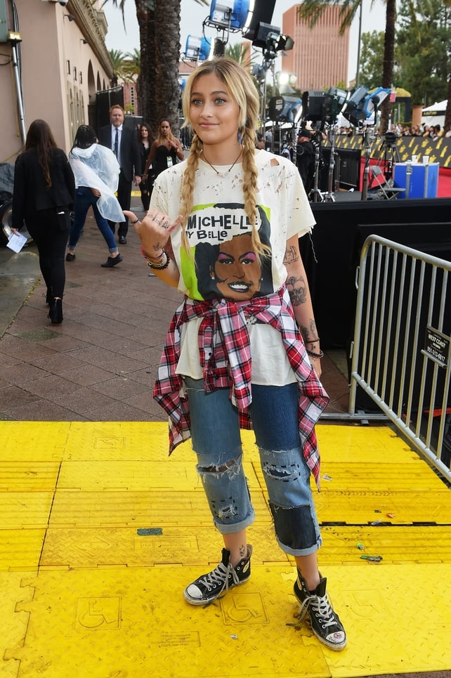 Paris Jackson is bringing the 90s back with her black converse, peddle pusher jeans, plaid shirt and over sized t-shirt. We're obsessed.
