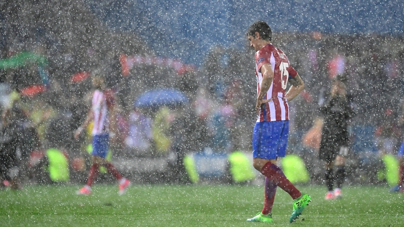 Heavy rain falls on Atletico Madrid defender Stefan Savic