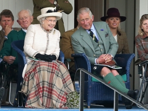 Queen Elizabeth II and Prince Charles watch the action during the Braemar Highland Games in 2014.