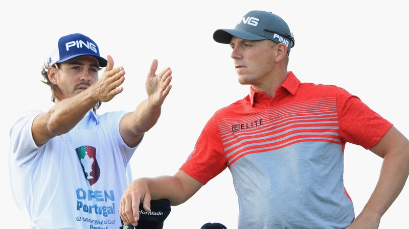 Wallace listens to the advice of his caddy in Portugal
