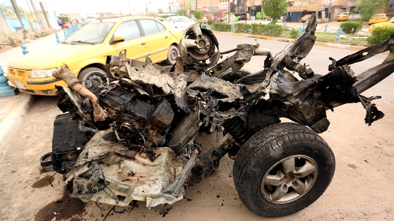 A wrecked car at the site of a suicide car bomb attack that targeted a police checkpoint in Baghdad