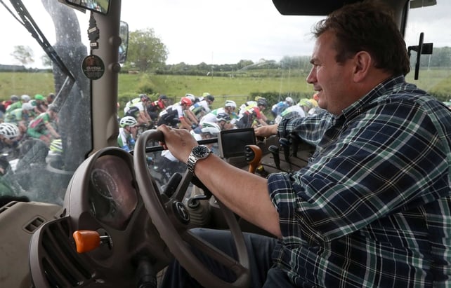 Jonathan McCord watches the peloton pass his tractor outside Lanesborough