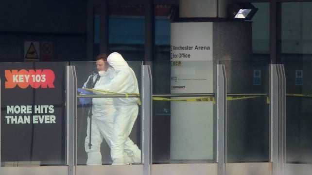 Police forensic investigators walk along a bridge linking Victoria Station with the Manchester Arena where the suspected terrorist attack at the end of a concert by US star Ariana Grande left 22 dead