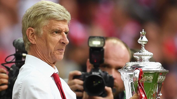 Wenger poses for photos with the cup after victory over Chelsea